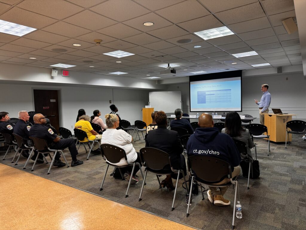 People sitting in a room facing a presentation screen